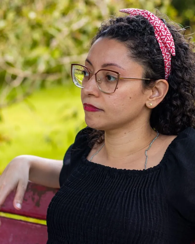 Diana Januário, nutricionista, sentada em um banco ao ar livre